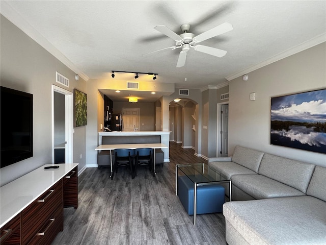 living room with rail lighting, crown molding, a textured ceiling, dark hardwood / wood-style flooring, and ceiling fan