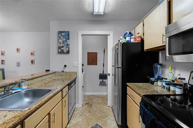 kitchen featuring a textured ceiling, light tile floors, appliances with stainless steel finishes, and sink