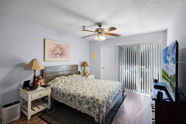 bedroom featuring a textured ceiling, ceiling fan, and dark wood-type flooring