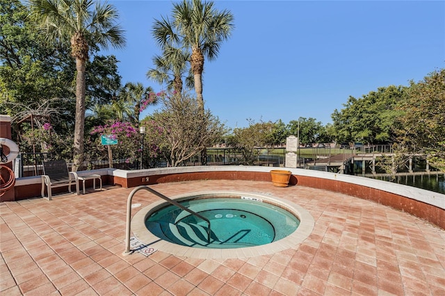 view of swimming pool with a water view, a patio, and a hot tub