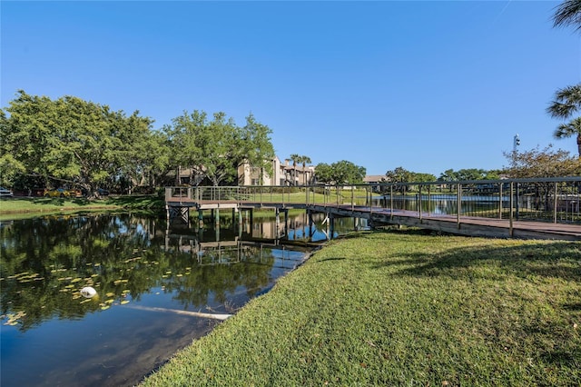 dock area with a lawn and a water view