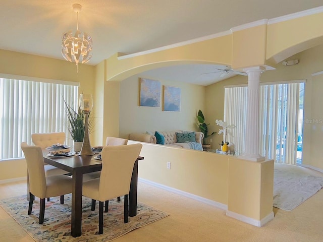 dining space with decorative columns, light colored carpet, and ceiling fan with notable chandelier