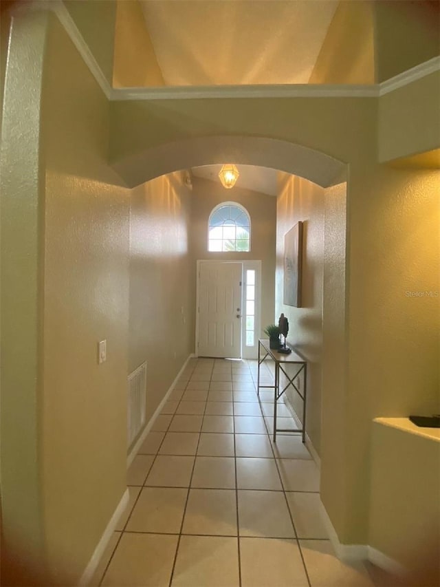 hallway featuring light tile floors and crown molding