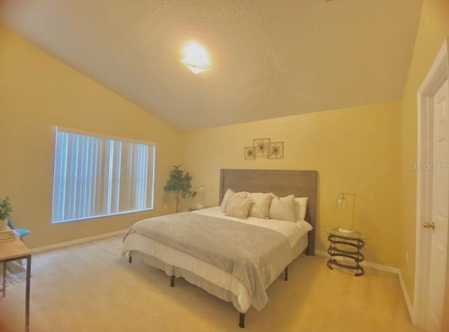 bedroom featuring lofted ceiling, light colored carpet, and a textured ceiling