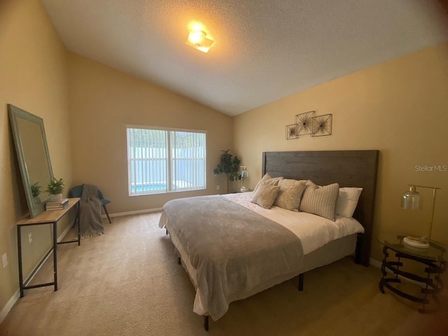 bedroom with light carpet, a textured ceiling, and lofted ceiling