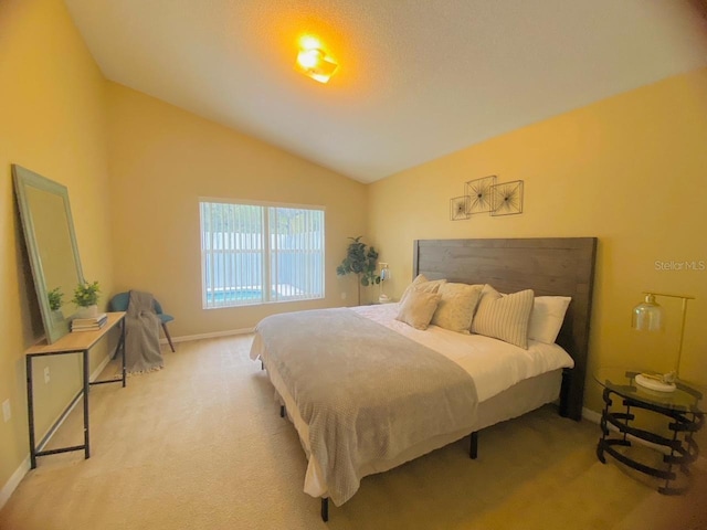 carpeted bedroom featuring lofted ceiling