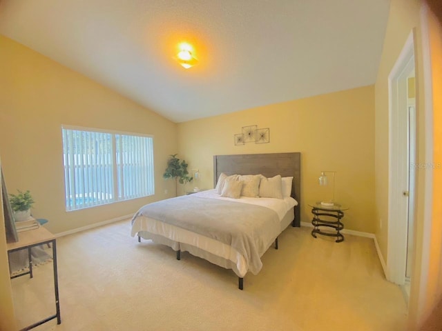 bedroom with lofted ceiling and light colored carpet