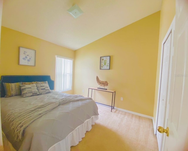 carpeted bedroom featuring a closet and vaulted ceiling