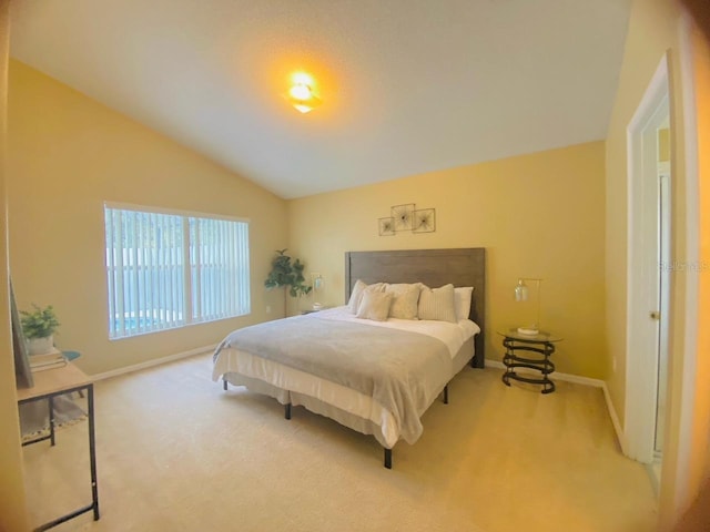 bedroom featuring lofted ceiling and light colored carpet