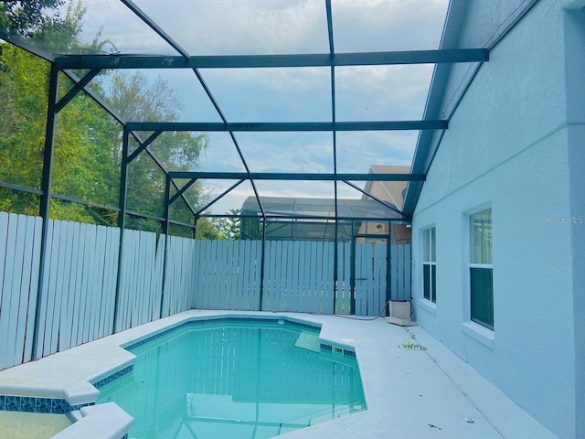 view of swimming pool featuring glass enclosure