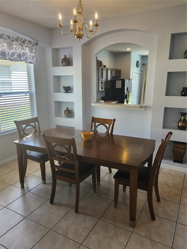 dining room featuring tile patterned floors, built in features, a textured ceiling, and a chandelier