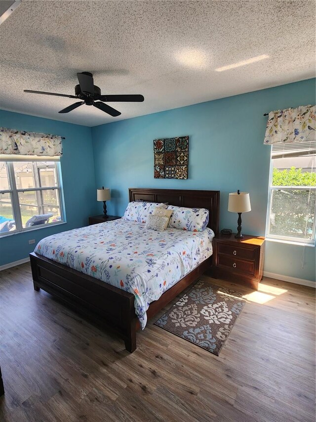 bedroom featuring hardwood / wood-style floors, a textured ceiling, and ceiling fan