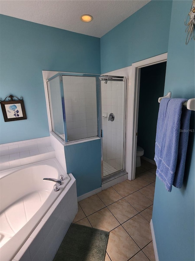 bathroom featuring tile patterned floors, toilet, a textured ceiling, and shower with separate bathtub