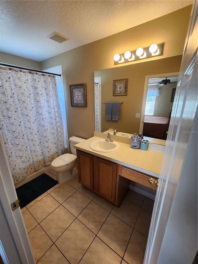 bathroom featuring tile patterned floors, vanity, a textured ceiling, ceiling fan, and toilet