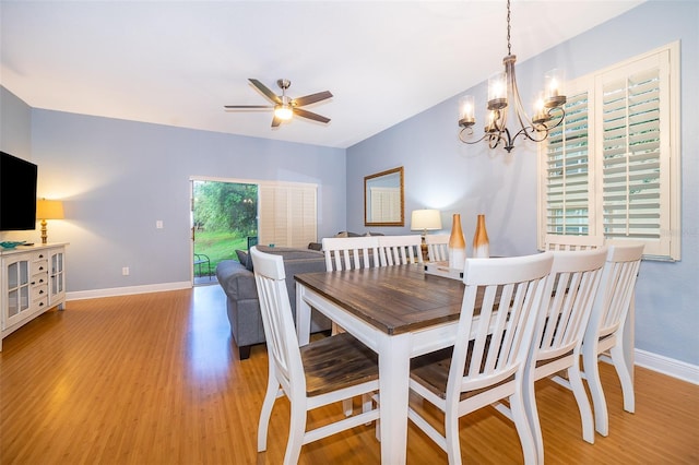 dining area featuring ceiling fan with notable chandelier and light hardwood / wood-style flooring