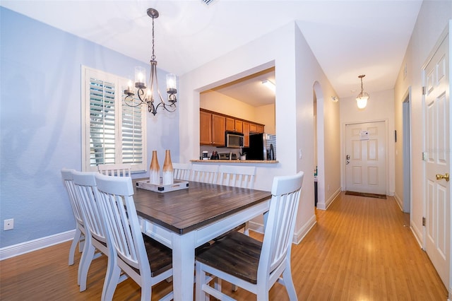 dining area featuring an inviting chandelier and light hardwood / wood-style floors