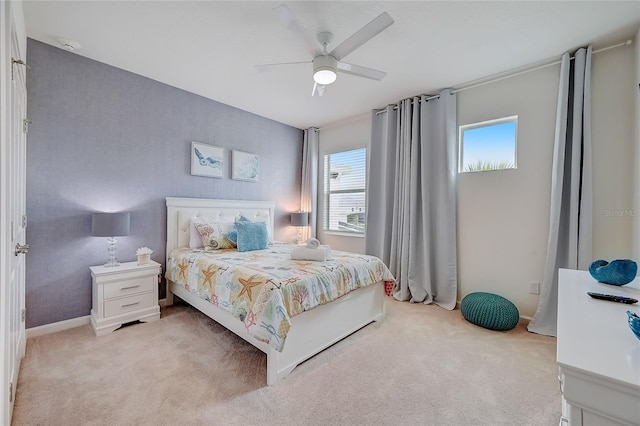 bedroom with multiple windows, light carpet, and ceiling fan