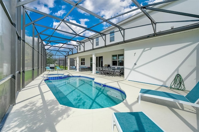 view of swimming pool featuring a patio area, glass enclosure, and an in ground hot tub