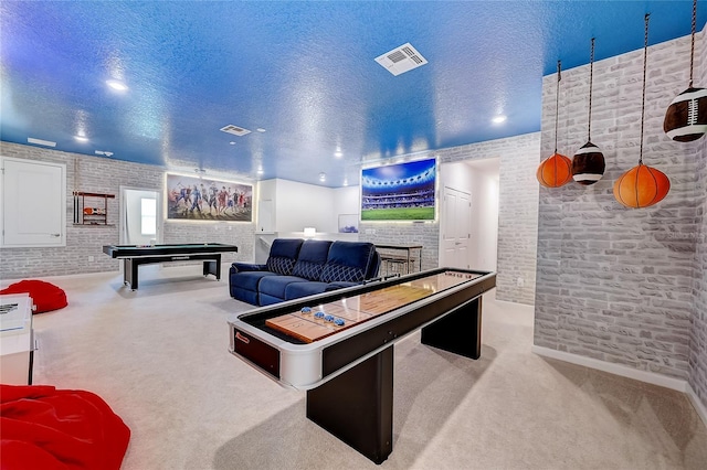 playroom with pool table, brick wall, a textured ceiling, and light colored carpet