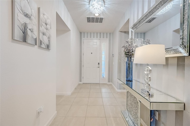 tiled entryway with a textured ceiling