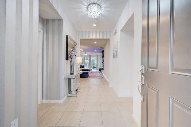 entryway with light tile patterned flooring and a chandelier