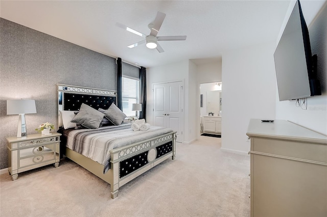 carpeted bedroom with ceiling fan, ensuite bathroom, and a closet