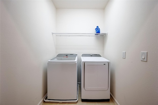 laundry area with light tile patterned floors and washer and clothes dryer