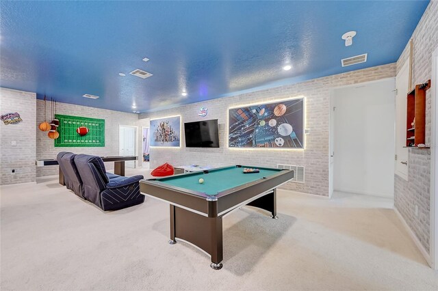 rec room featuring brick wall, billiards, a textured ceiling, and light colored carpet