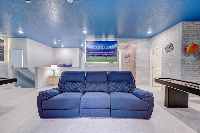 carpeted living room with brick wall and a textured ceiling