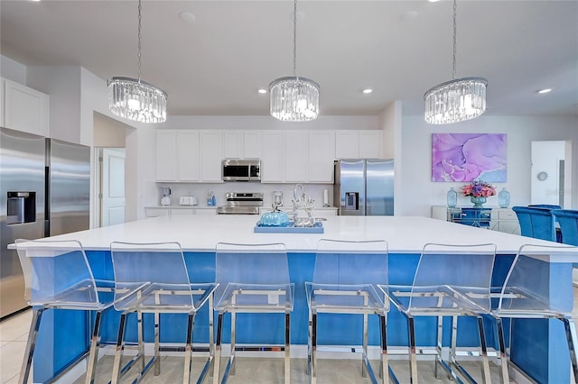 kitchen featuring a spacious island, a breakfast bar area, pendant lighting, and appliances with stainless steel finishes