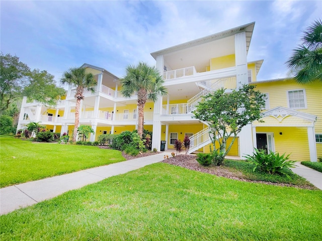 exterior space featuring a balcony and a front yard