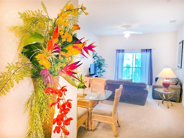 carpeted dining room featuring ceiling fan