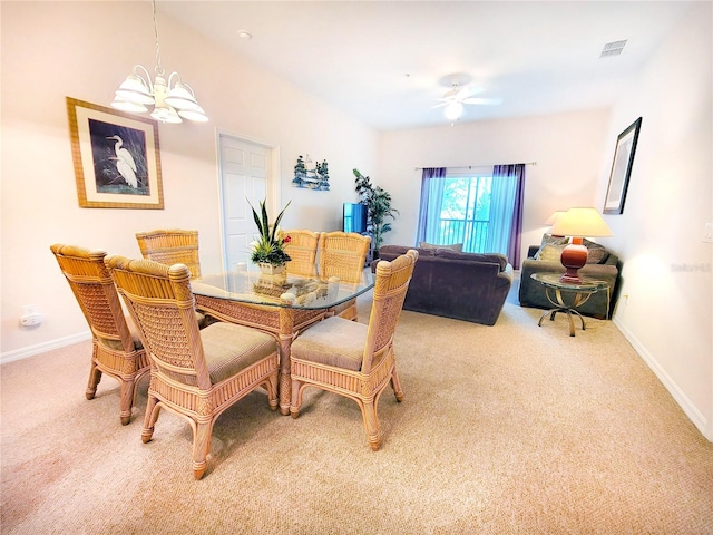 dining area featuring light carpet and ceiling fan with notable chandelier