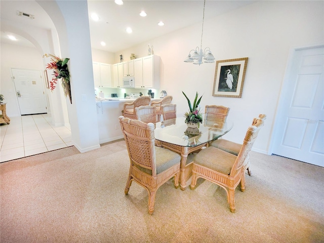 carpeted dining room featuring a notable chandelier