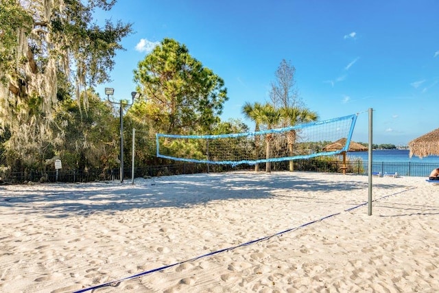 view of home's community featuring volleyball court and a water view