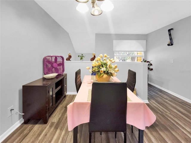 dining space featuring lofted ceiling, a chandelier, and hardwood / wood-style flooring