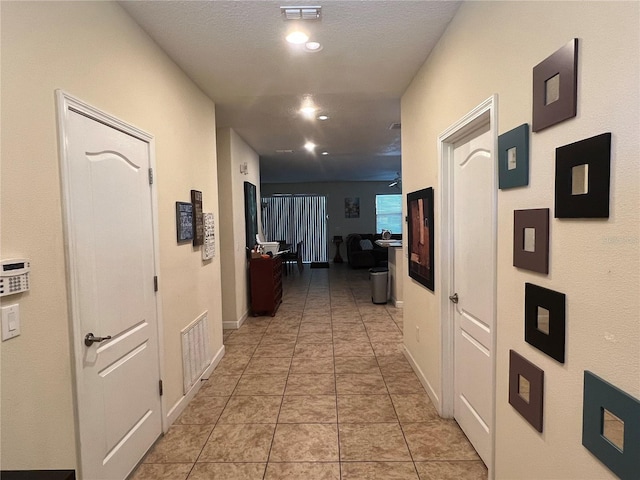 hall featuring light tile patterned floors