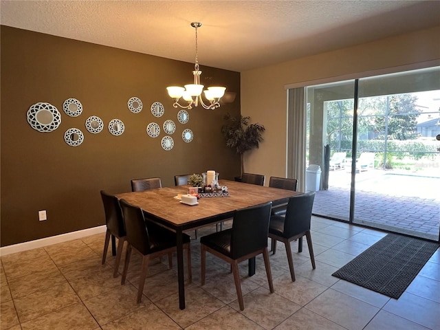 dining room with light tile patterned flooring, a textured ceiling, and a chandelier