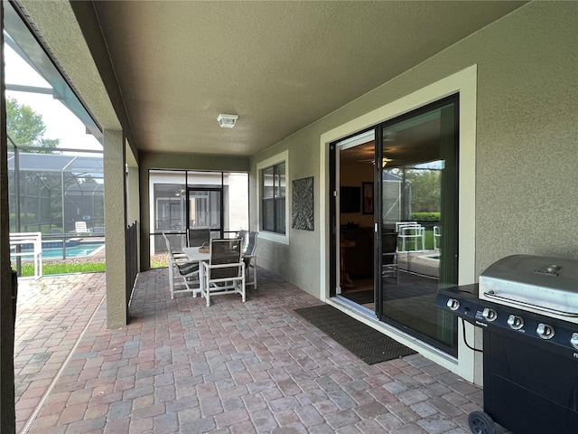 view of patio with a grill and glass enclosure