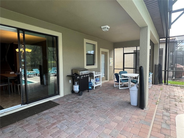 view of patio featuring area for grilling and glass enclosure