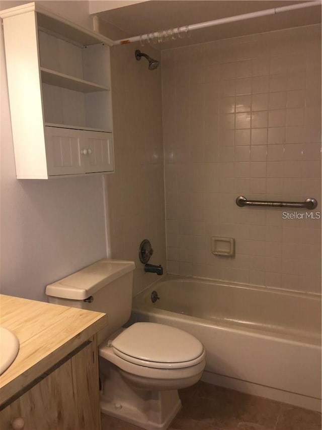 full bathroom with vanity, tiled shower / bath combo, tile patterned floors, and toilet