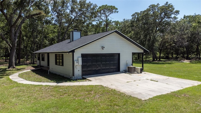 garage with central air condition unit and a yard