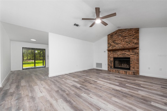 unfurnished living room featuring a fireplace, ceiling fan, vaulted ceiling, and light wood-type flooring