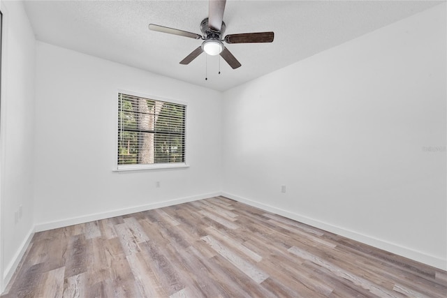 spare room featuring a textured ceiling, ceiling fan, and light wood-type flooring