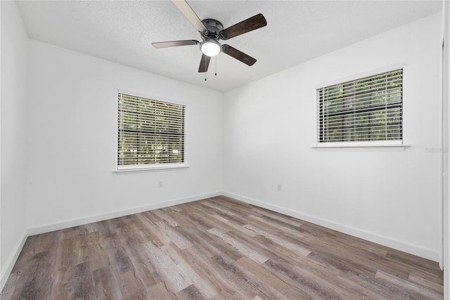 spare room with ceiling fan and light wood-type flooring