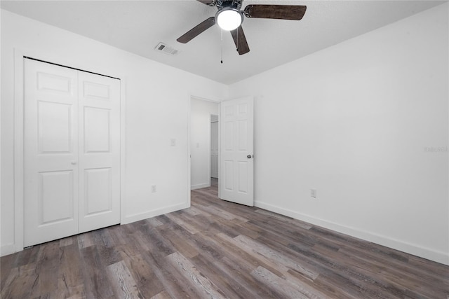 unfurnished bedroom with dark hardwood / wood-style floors, a closet, and ceiling fan