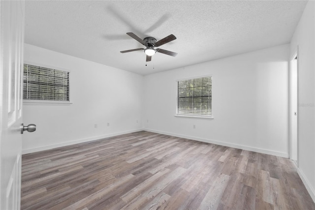 empty room with light hardwood / wood-style flooring, ceiling fan, and a textured ceiling