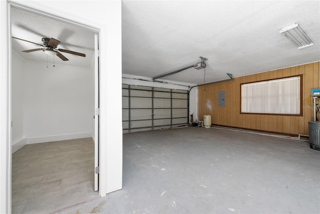 garage featuring wooden walls, ceiling fan, and a garage door opener