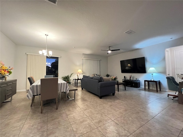 tiled living room featuring ceiling fan with notable chandelier