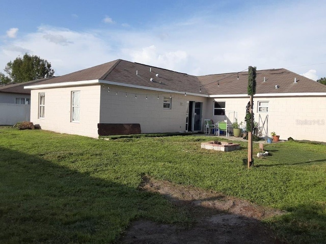 back of house featuring a lawn